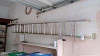 Photo of aluminum extension ladder stored horizontally showing full length and wear condition