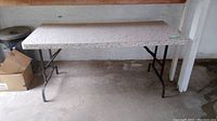 Full view of folding table showing the top and metal legs.