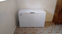 Image of white Beaumark chest freezer positioned in a corner of the room with tiled flooring.