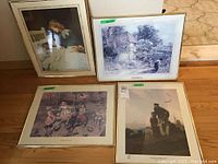 Four framed prints displayed on a wooden floor showing all items in the lot.