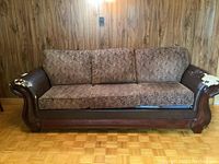 Full front view of the three seater sofa showing fabric upholstery and faux leather arms with visible damage.