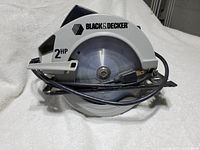 Front view of the Black & Decker circular saw showing the blade, power rating (2 HP), brand and power cord with plug.