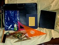 Photo showing the assortment of drafting tools and two black portfolio storage items.