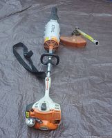 Overview of powerhead, blower and trimmer attachments laid flat