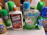 Photo showing various floor and surface cleaning products including Quick Shine Floor Luster, Mr Clean, Scotchgard, and Scrubbing Bubbles.