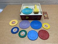 Full set image showing the vintage Fisher Price Music Box Record Player with all 9 discs arranged in front.