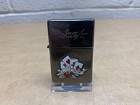 Front view of the limited edition Sailor Jerry lighter showing the engraving and colorful emblem.