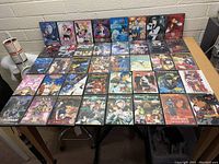 Photo of the full lot of 42 anime DVDs arranged on a table showing front covers.