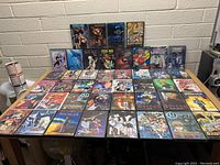 Lot of 39 anime DVDs arranged on a table including Spirited Away, Nausicaa, Fairy Tail, and others.