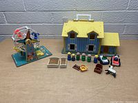 Full lot overview showing playhouse, Ferris wheel, peg people, toy vehicles, horse, and furniture