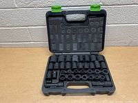 Photo of black plastic carrying case open with sockets and adapters neatly arranged inside.
