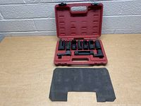 Red plastic carrying case with oxygen sensor sockets arranged inside, black foam insert in front.