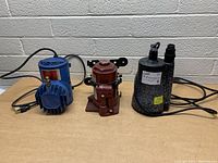 Front view of all three items on wooden table with power cords visible and wall backdrop.