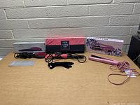 Full view of the three styling tools with boxes including the Sutra heated brush, Bebe flat iron, and Soleil curling iron.