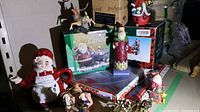 Group photo showing various Christmas decorations including Mrs. Claus teapot, Santa figurine, candle holder box, ornaments, and platters grouped together