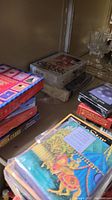 Stack of several boxed card decks and a book on a shelf including New Age themed items and a King Arthur title.
