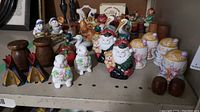 Wide angle photo showing multiple sets of vintage ceramic salt and pepper shakers including Santas, bunnies, teepees, animals, and wooden varieties.