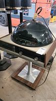 Full view of Viking stereo system with domed cover and wood-metal stand.