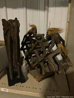 Photo showing the carved wooden elephant figure with elongated legs and trunk, standing upright with visible wear.