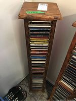 Wooden CD stand filled with mixed music CDs seen from the front.
