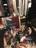 Various cleaning devices including upright vacuum, handheld vacuums, robotic vacuum, and car vacuum along with fabric storage organizers.