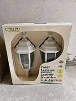Boxed pair of Coach branded outdoor lanterns in original packaging labeled Catalina lighting.