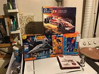 Photo showing Williams FW21 3D puzzle box along with Star Wars Command, Meteor Rocket puzzle, and miniature Stanley Cup boxes arranged together on a surface.