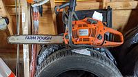Full side view of orange Husqvarna 455 Rancher chainsaw with 19-inch Farm Tough bar and chain.