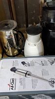 Krups coffee grinder and Nespresso milk frother, manual chopper with All-Clad immersion blender box in front