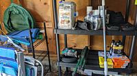Photo of black metal wire shelf with various items on it in a garage space.