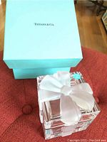 Photo of Tiffany & Co blue box with glass crystal gift box topped with a white bow inside.