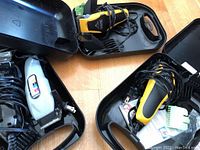Three black cases containing electric shavers and hair clippers from Wahl and Conair, cords and some accessories visible inside cases.