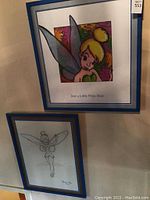 Two framed Tinker Bell pictures hanging on a wall, top piece is colorful and bottom piece is a pencil sketch.