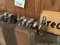 Metal animal sculptures displayed on a brick ledge with a wooden 'Breckenridge 2014' sign in background. Several small metal animals are lined up, showing different animal shapes such as bears and giraffes.