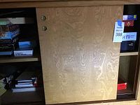 Wooden cabinet shelf with stacked games and puzzles