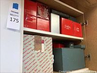 Shelf of red Gorham and green Lenox boxes