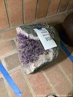 Side view of the large amethyst geode showing the exterior and crystal interior.