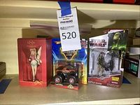 Lenox Disney Pixie Fairy ornament in red box, Hot Wheels Monster Jam truck, Star Wars Battle Droid figure together on shelf