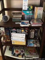 Photo showing shelves with puzzles, blank CD discs, Disney books and software at bottom