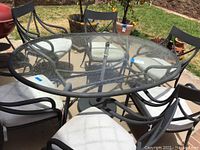 Top-down view of round glass-top table surrounded by six chairs