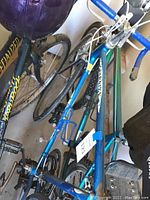 Blue Schwinn Varsity bicycle frame and partial drivetrain visible, including pedals and water bottle holder.