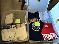 Two plastic bins with folded vintage T-shirts visible on top