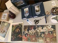 Photo showing two Liberty Puzzles boxes, two books in slipcases, scissors, pen, puzzle pieces in container, and some puzzle artwork.