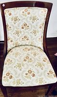 Front view of wooden chair with floral upholstery on backrest and seat