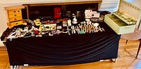 Wide view of all jewelry, pens, boxes, and accessories laid out on a cloth-covered table.