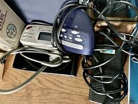 Photo showing digital blood pressure monitor with cuff and accompanying cables on a wooden surface.