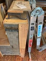 Photo showing Stanley mitre box mounted on wood next to aluminum Krause ladder