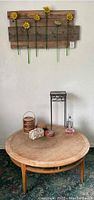 Round wooden coffee table with some scratches and various small decorative items arranged on top