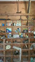 Photo showing wooden shelving unit with hand tools and chemical bottles arranged on shelves
