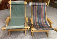 Front view of two wooden folding lounge chairs side-by-side showing one with solid green fabric and the other with multicolor striped fabric